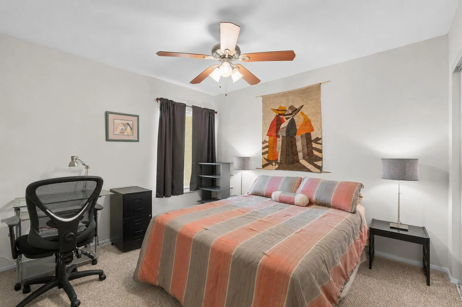 Secondary bedroom with carpet flooring, ceiling fan, and a window that fills the room with natural light.