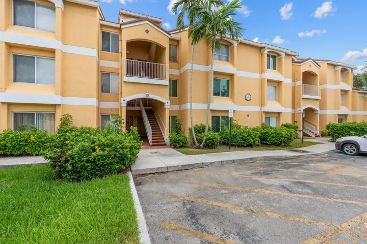 Building entrance features covered stair access and tropical landscaping that creates a welcoming arrival.