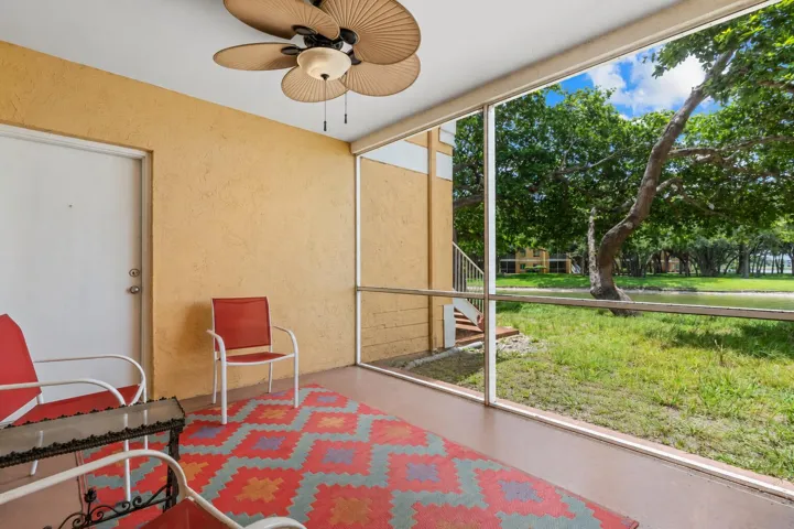 Screened patio offers a comfortable outdoor living space with peaceful views of the surrounding green space and lake.