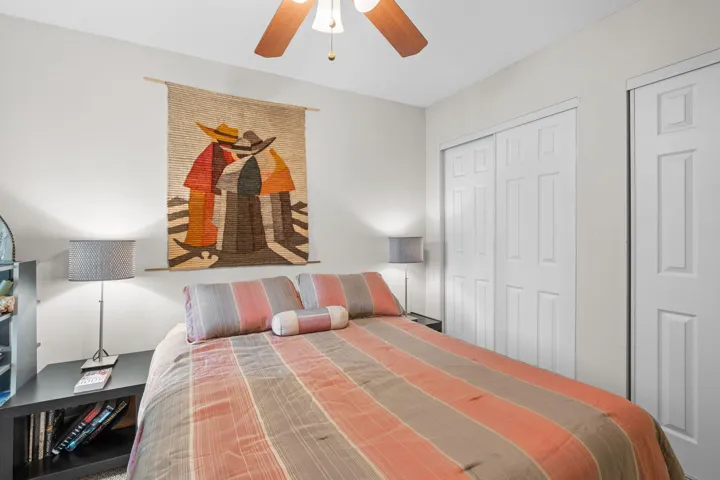 Secondary bedroom includes a ceiling fan, generous closet space, and a comfortable layout suited for guests or a home office.