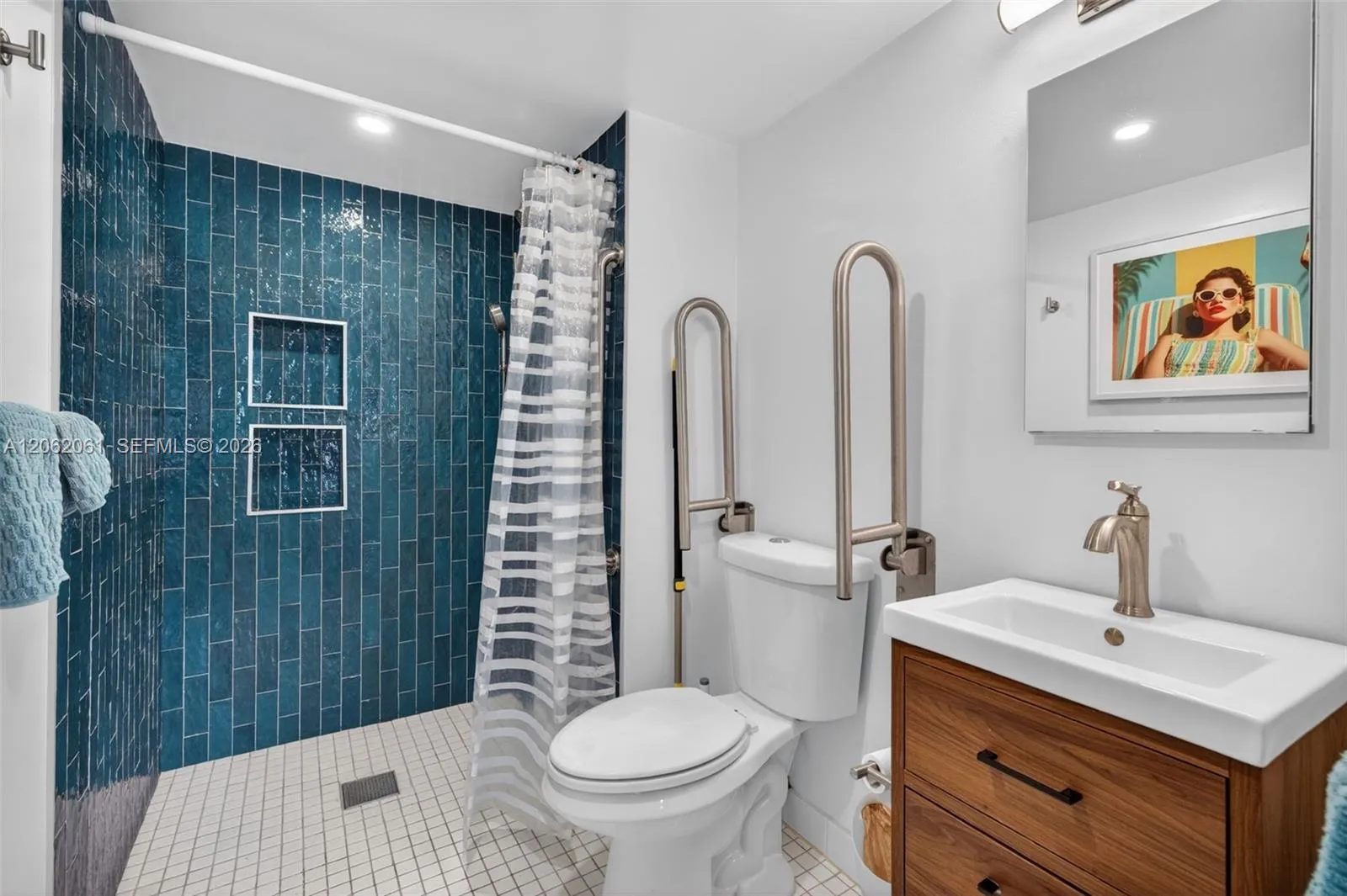 Primary bathroom offers a spacious roll-in shower with grab bars for comfort and ease of use.