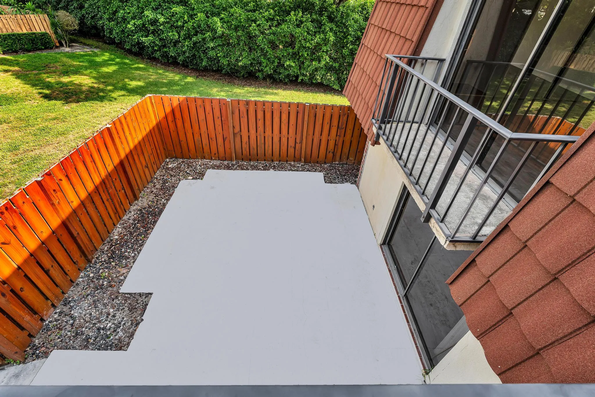 Private patio area with concrete surfacing and decorative gravel