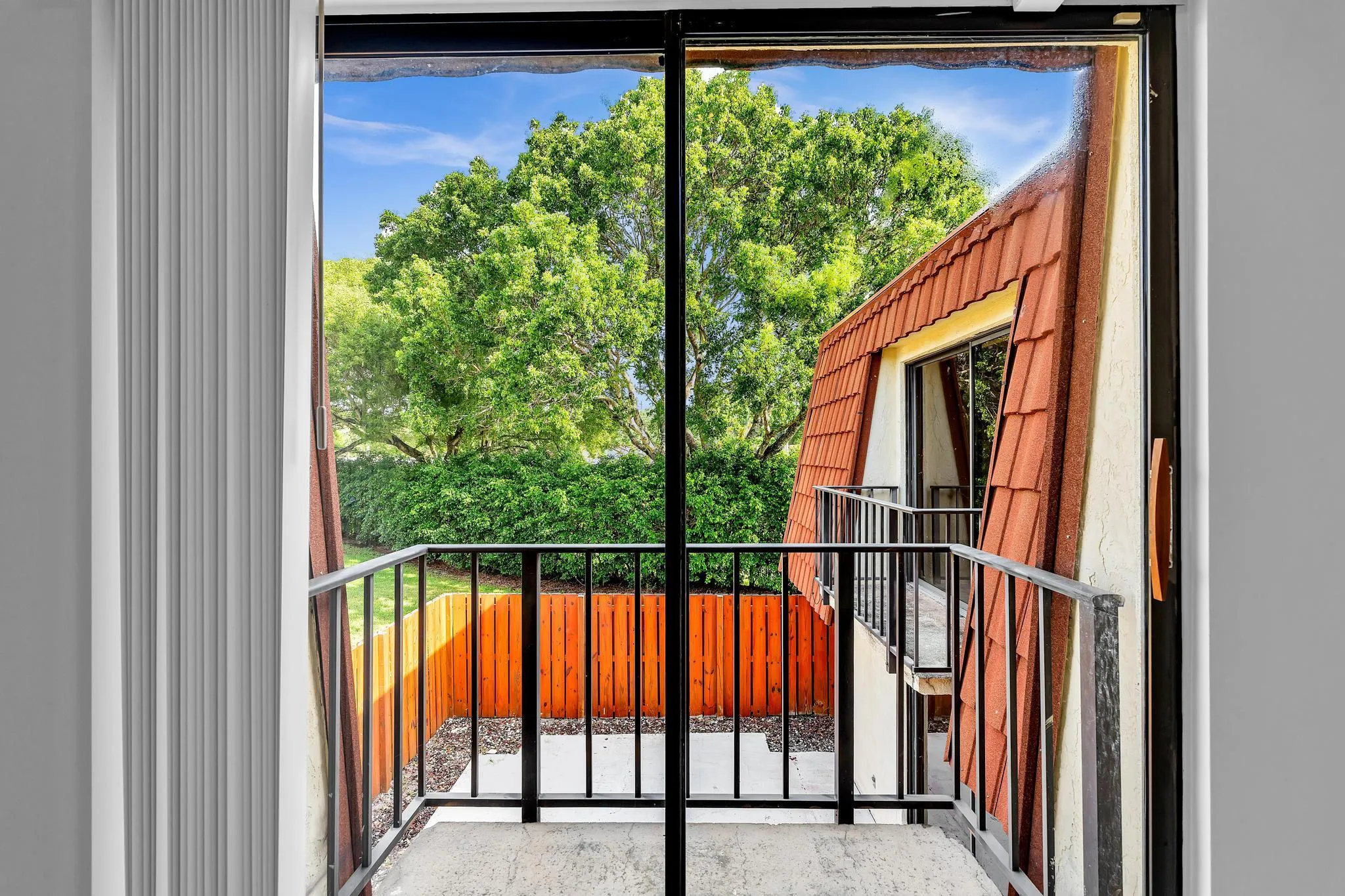 Sliding glass door leading to a private outdoor balcony with black metal railings