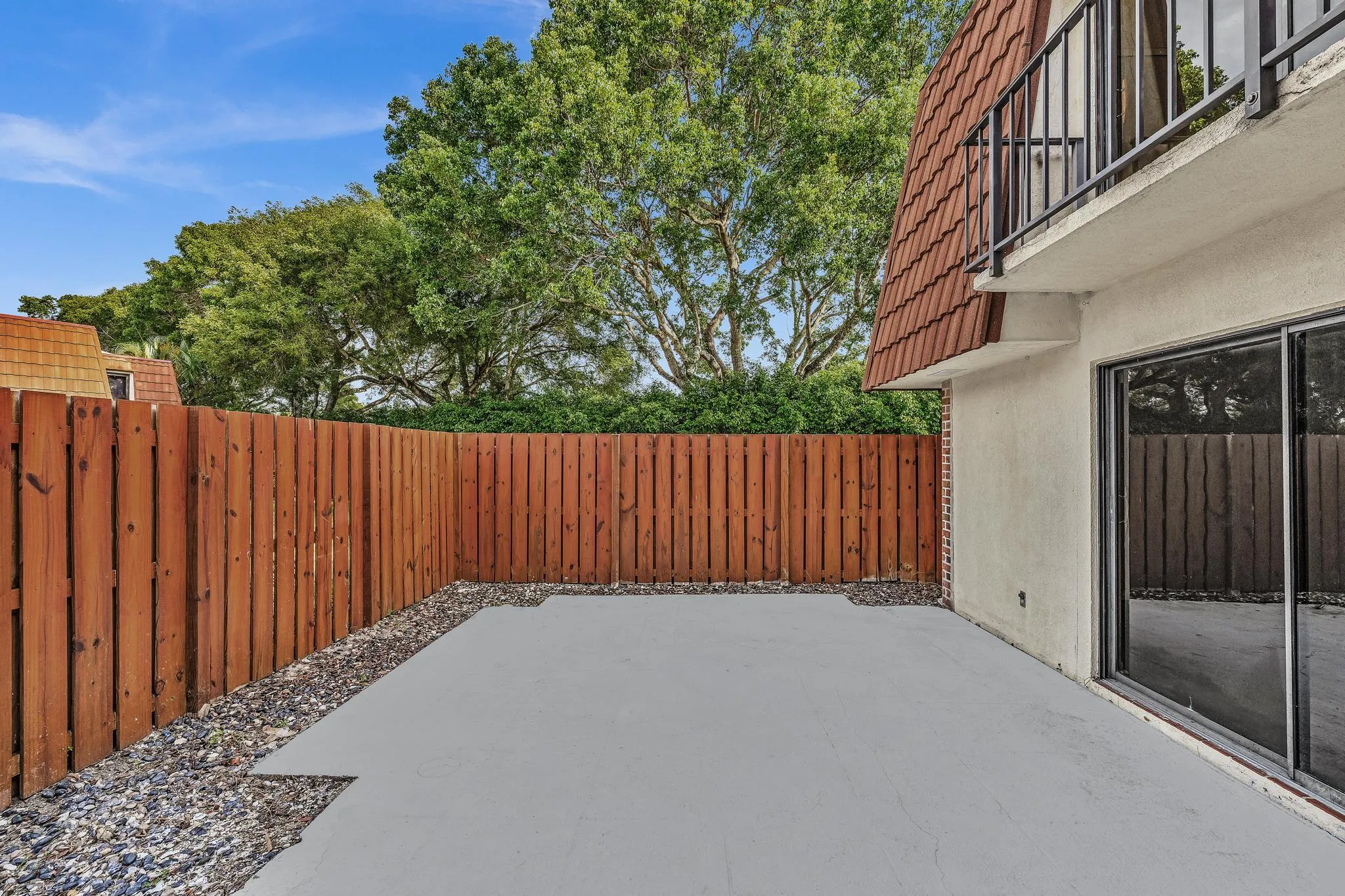 Private patio with concrete surfacing and surrounding gravel accents