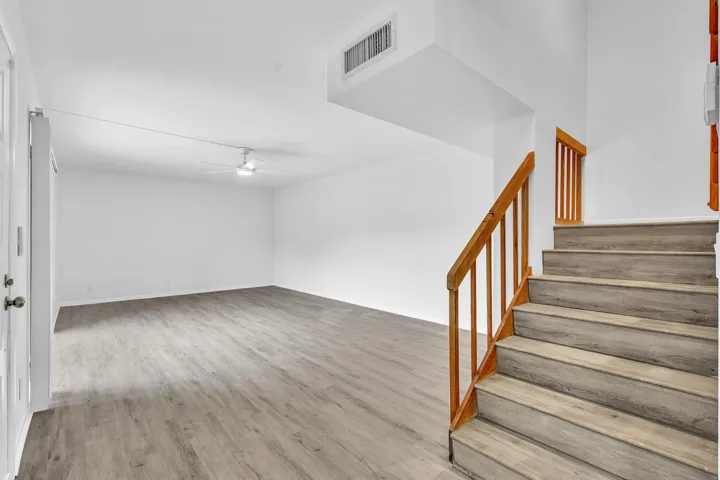 Bright interior with wood-finish flooring and a contemporary ceiling fan
