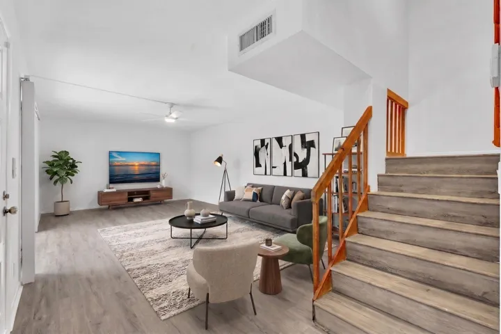 Spacious living area featuring wood-finish flooring and a ceiling fan