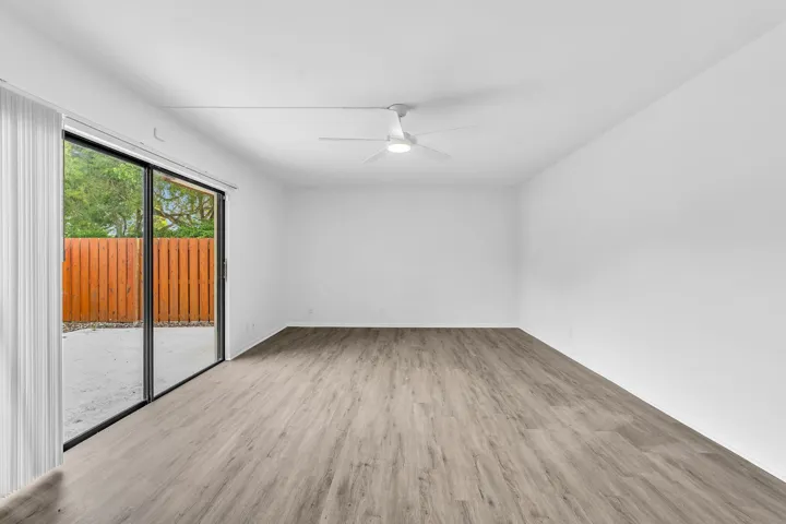 Expansive room featuring wood-finish flooring and a ceiling fan