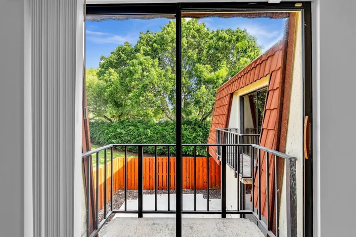 Sliding glass door leading to a private outdoor balcony with black metal railings