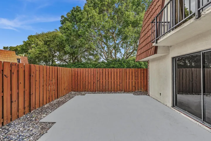 Private patio with concrete surfacing and surrounding gravel accents