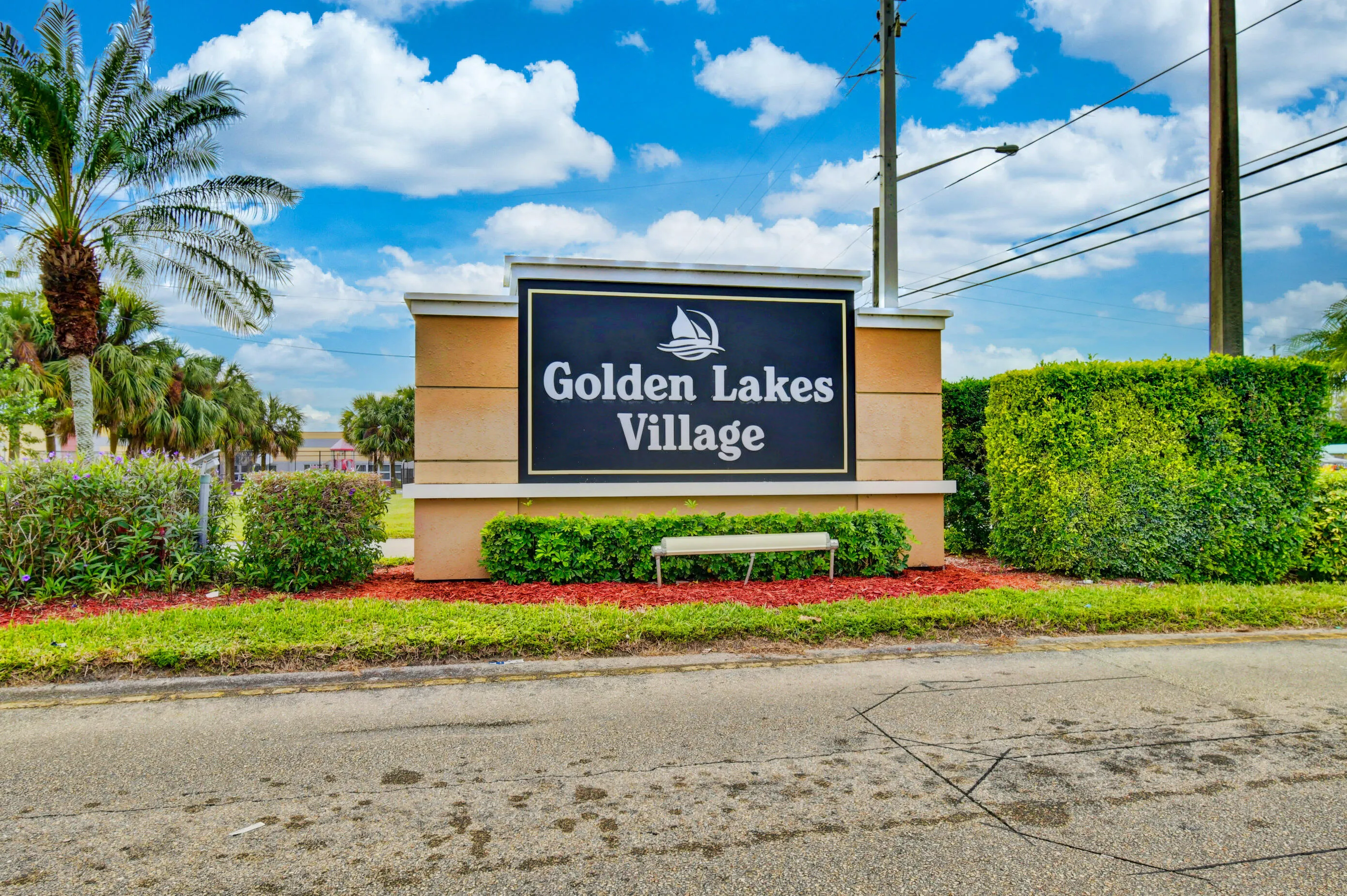 Community entrance signage featuring a cream-colored base with black lettering
