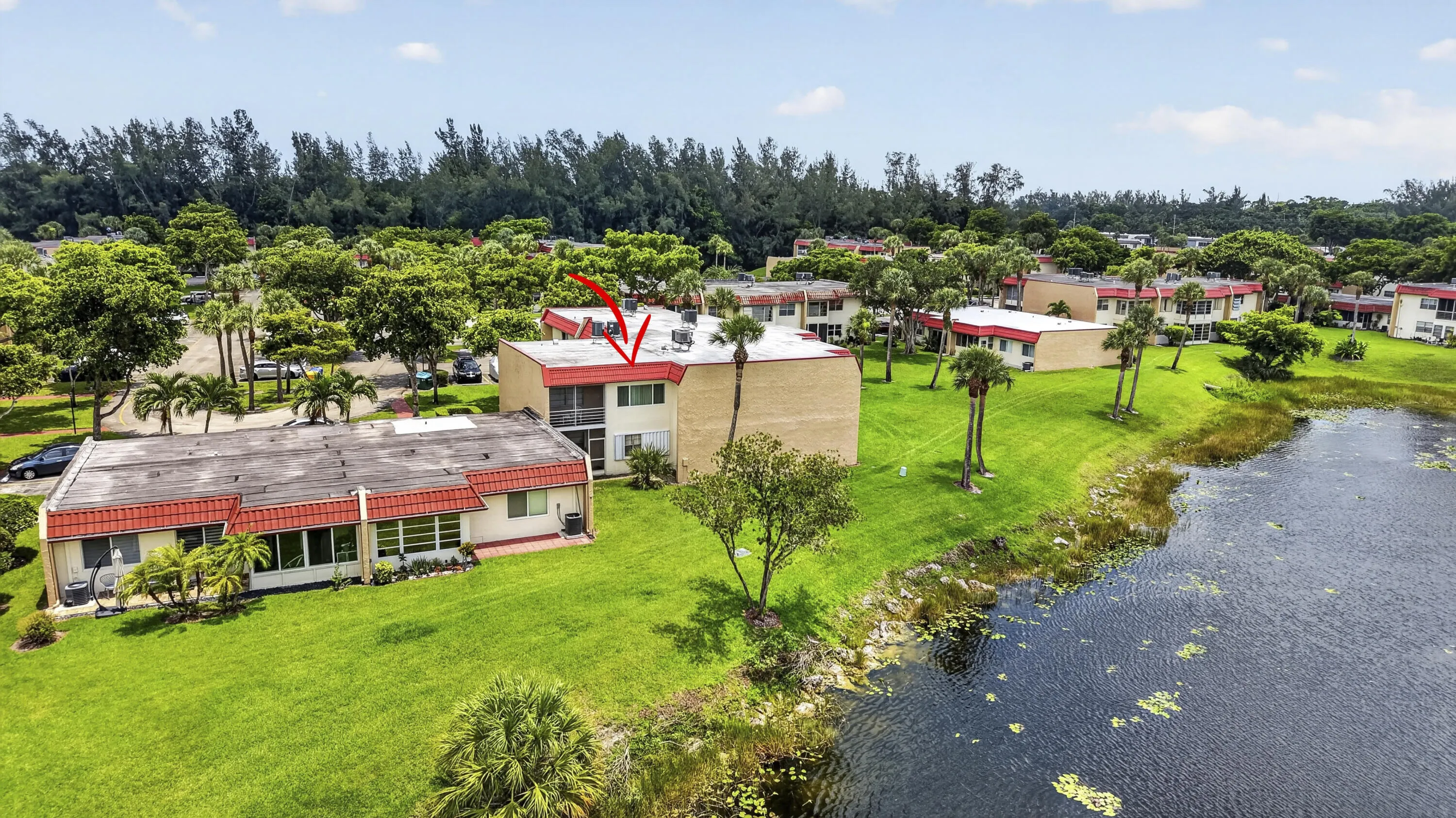 Waterfront building featuring a private balcony and a lush green landscape