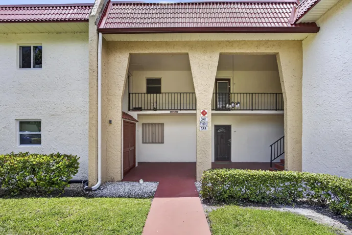 Multi-level exterior with a red tile roof and stucco finish
