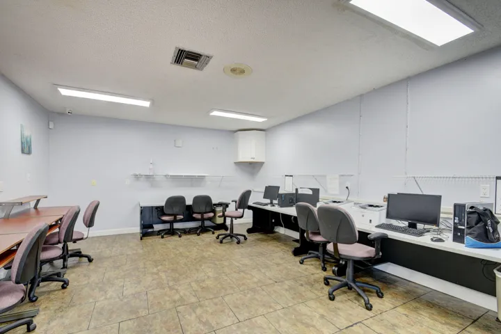 Spacious interior featuring a dropped ceiling with recessed lighting and rectangular fluorescent fixtures