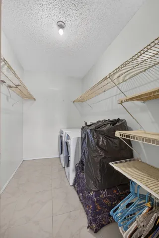 Laundry area with tile flooring and multiple wire shelving units