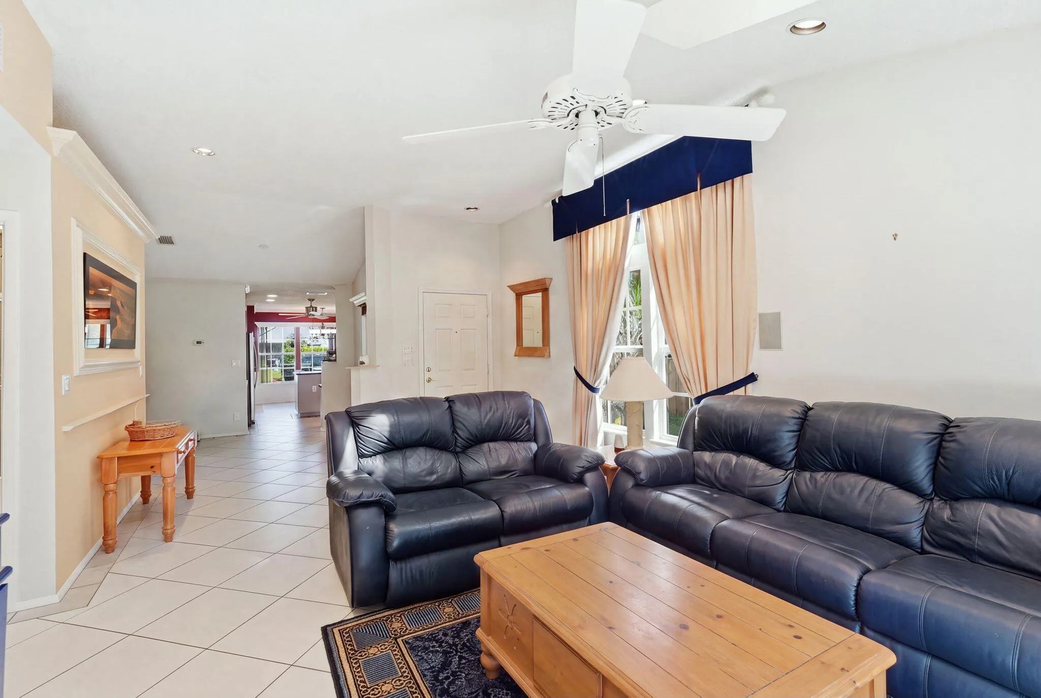 Living area featuring vaulted ceilings, recessed lighting, diagonal tile flooring, and a ceiling fan