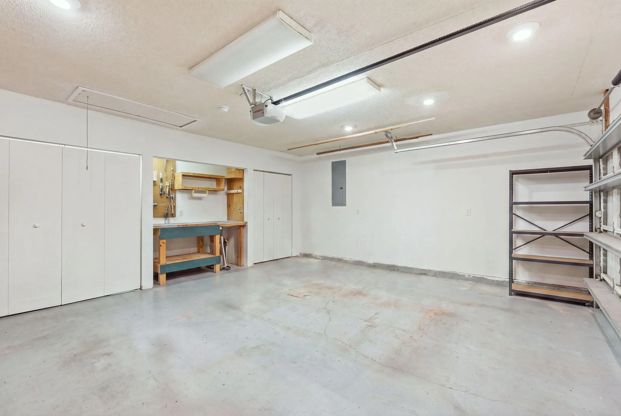 Spacious garage featuring concrete flooring and ample overhead lighting