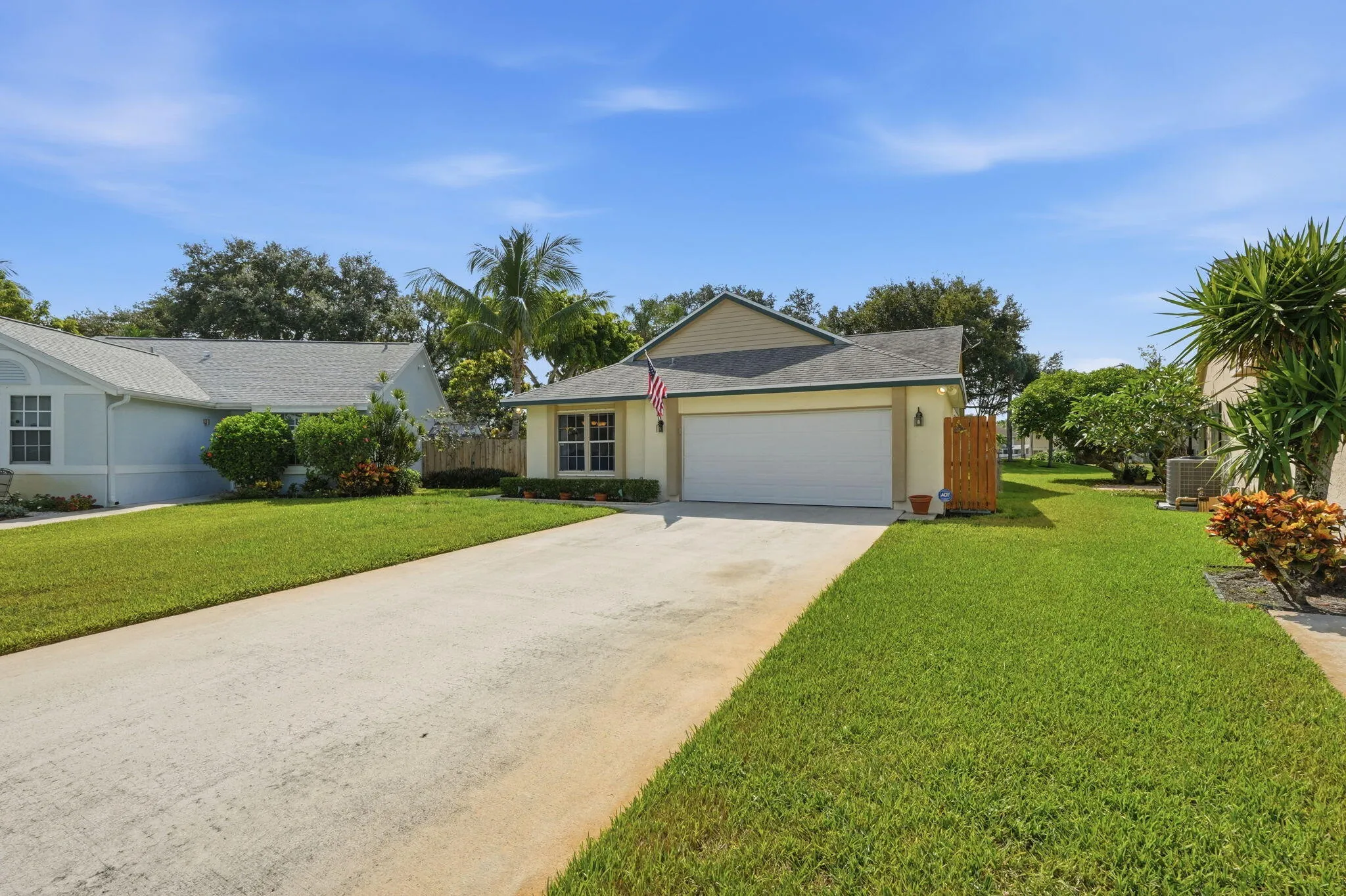 Single-story residence featuring a two-car garage, concrete driveway, and a well-kept lawn
