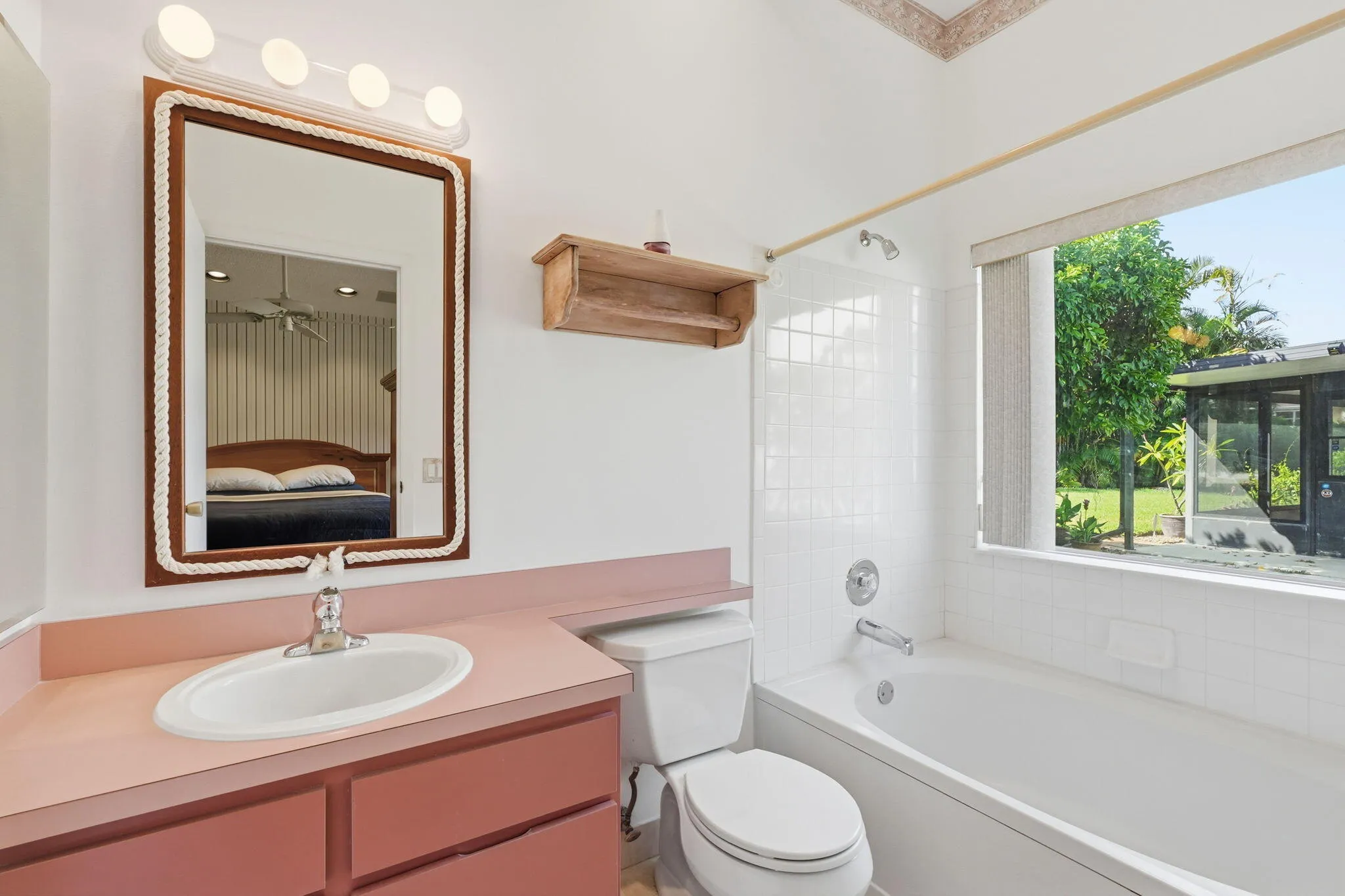 Bathroom featuring a vanity with an integrated sink, a rectangular mirror, and an overhead light fixture