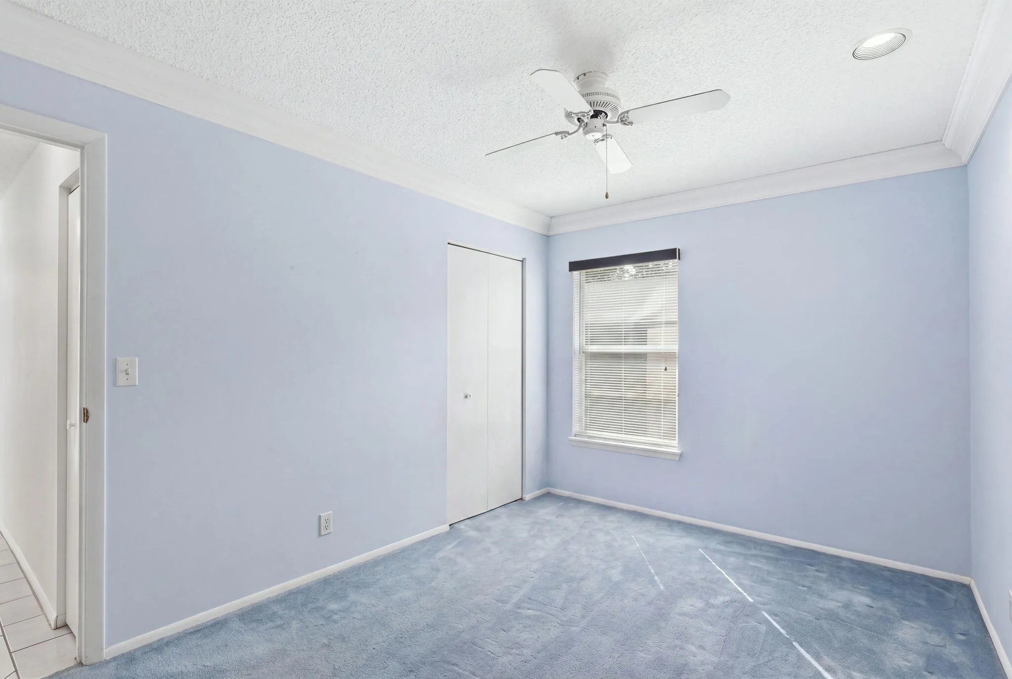 Carpeted room with a ceiling fan, recessed lighting, crown molding, and a window with blinds