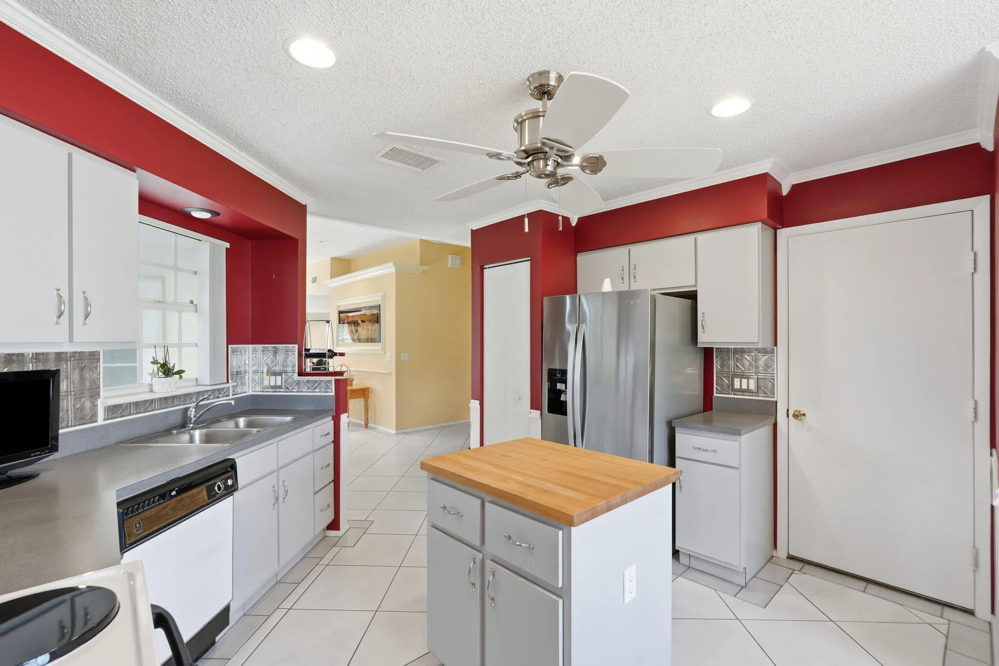Kitchen featuring white cabinetry, a central island with a wood countertop, and stainless steel appliances