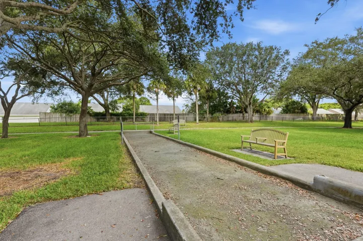 Bocce ball court featuring a gravel surface, concrete borders, and two park benches