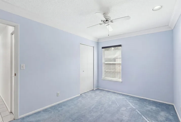 Carpeted room with a ceiling fan, recessed lighting, crown molding, and a window with blinds