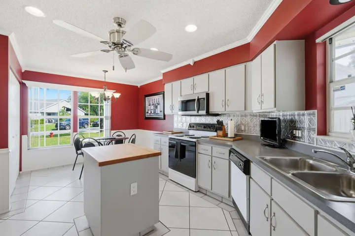 Kitchen with white cabinetry, stainless steel appliances, and a decorative tile backsplash