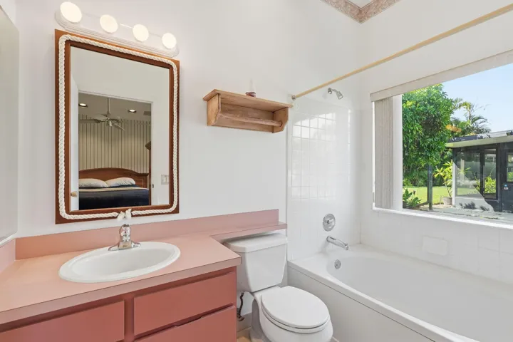 Bathroom featuring a vanity with an integrated sink, a rectangular mirror, and an overhead light fixture
