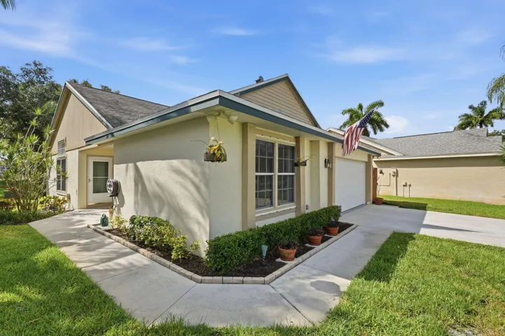 Front elevation featuring stucco siding, gabled roofline, and an attached garage