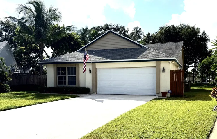 Front elevation featuring stucco siding, gabled roofline, and an attached garage