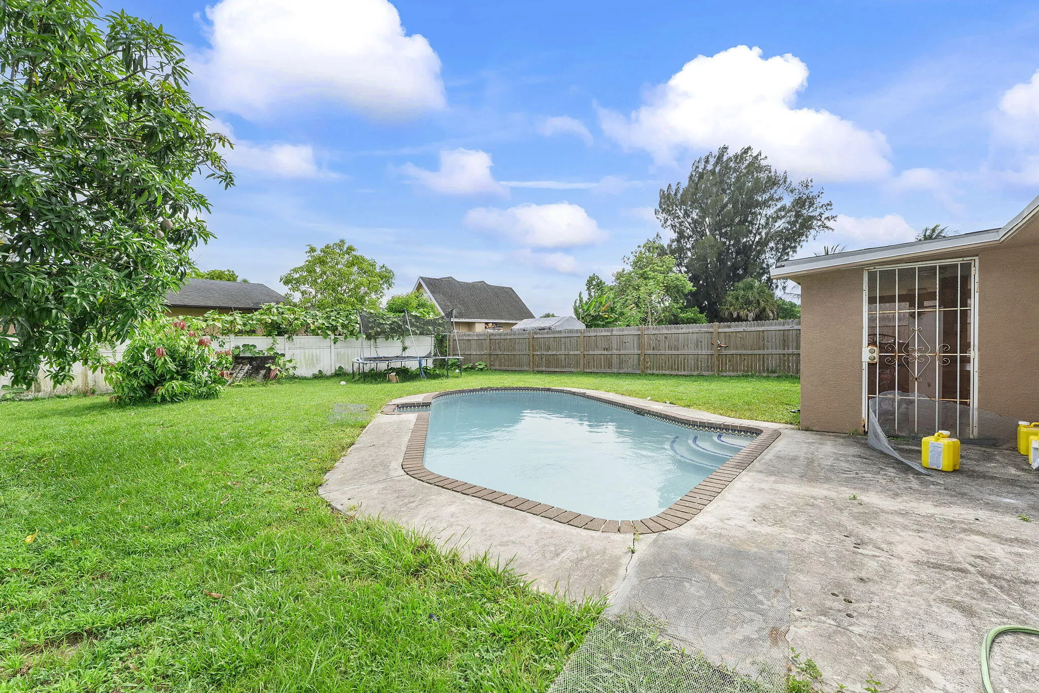 Backyard featuring an in-ground swimming pool with brick coping