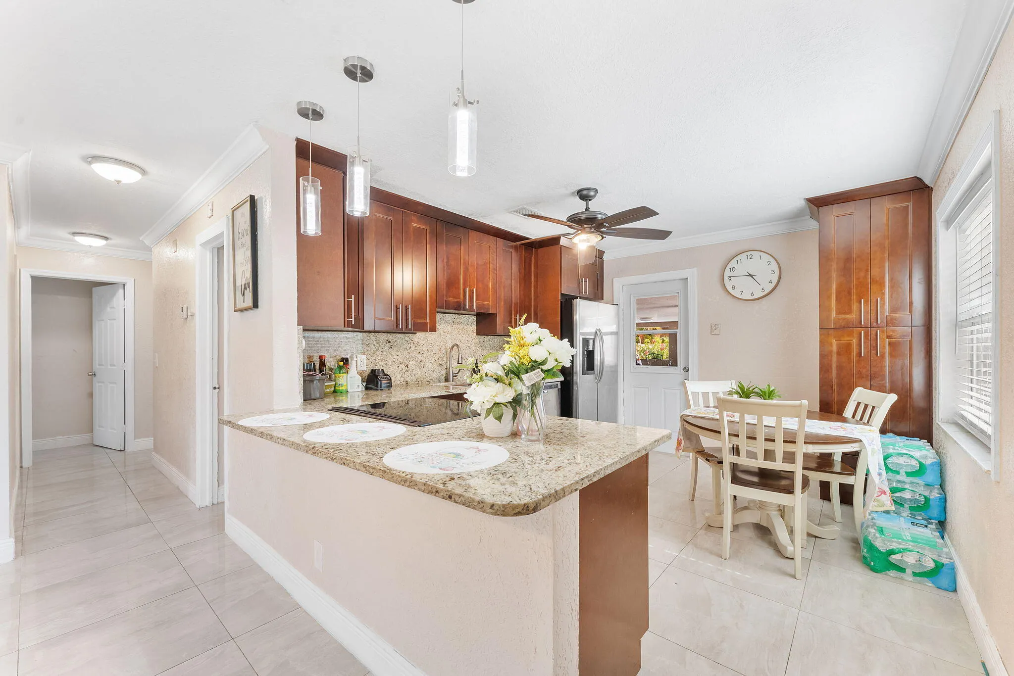 Kitchen featuring a granite-finish island, dark wood cabinetry, stainless steel appliances, and tile flooring