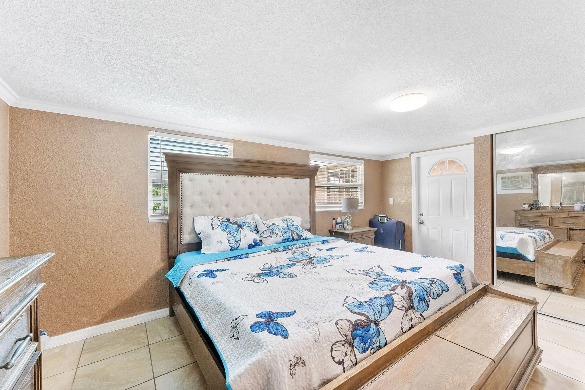 Tiled flooring complements textured walls and crown molding