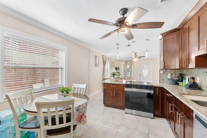 Kitchen featuring wood cabinetry, light granite countertops, a built-in oven, and a stainless steel sink