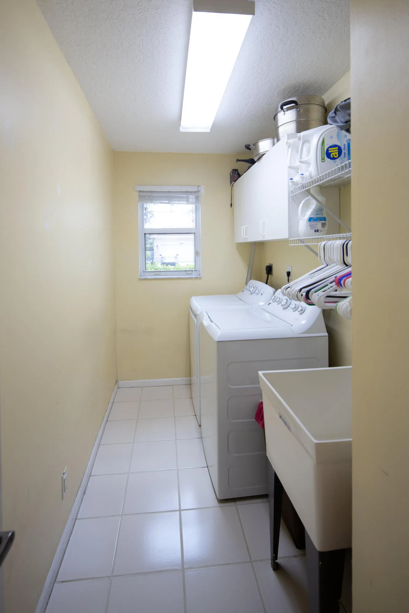 Separate laundry room with utility sink, storage space, and newer washer and dryer for added convenience.