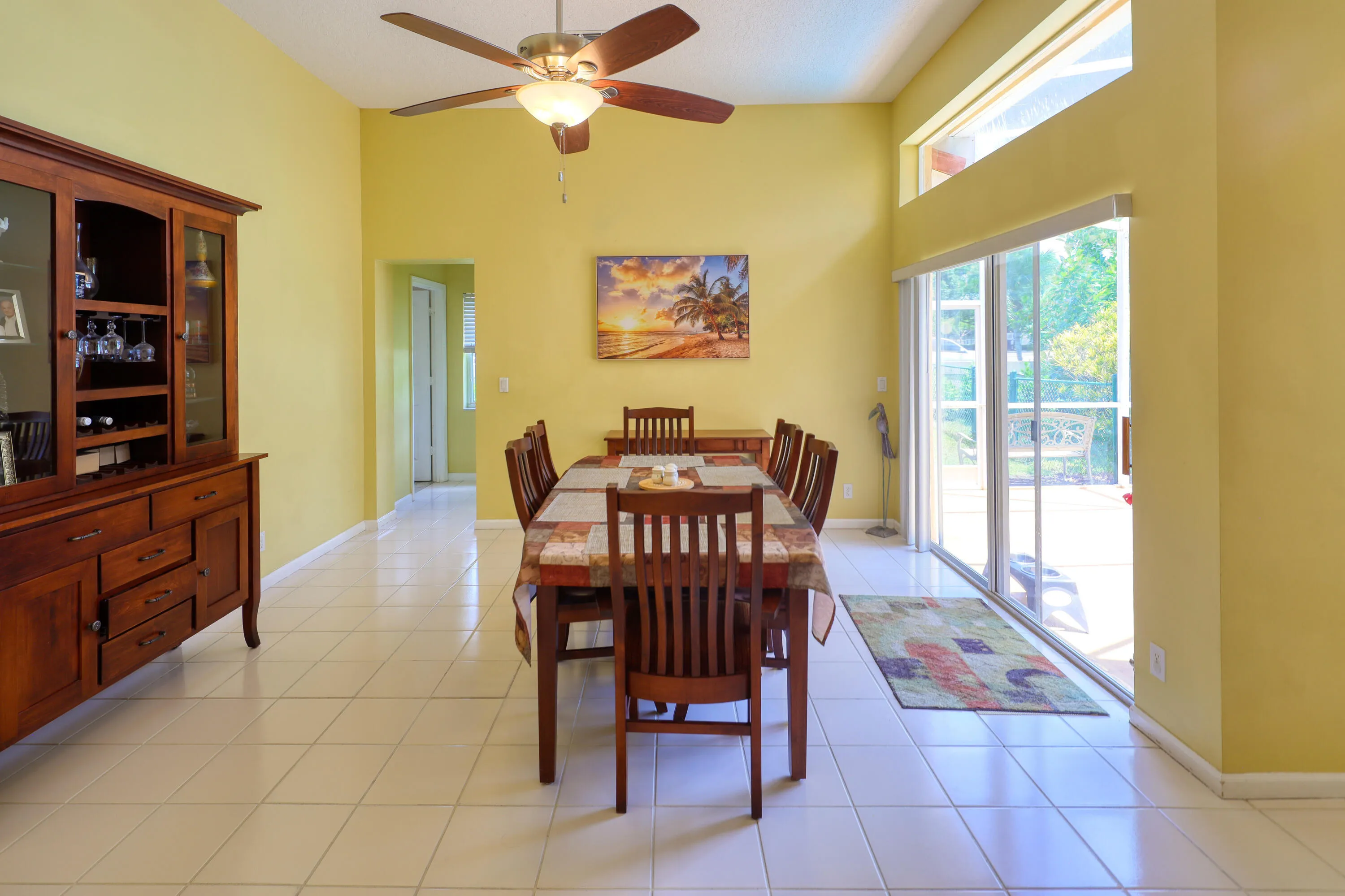 Flexible dining and living space with volume ceilings and sliding glass doors leading to the screened pool and patio.