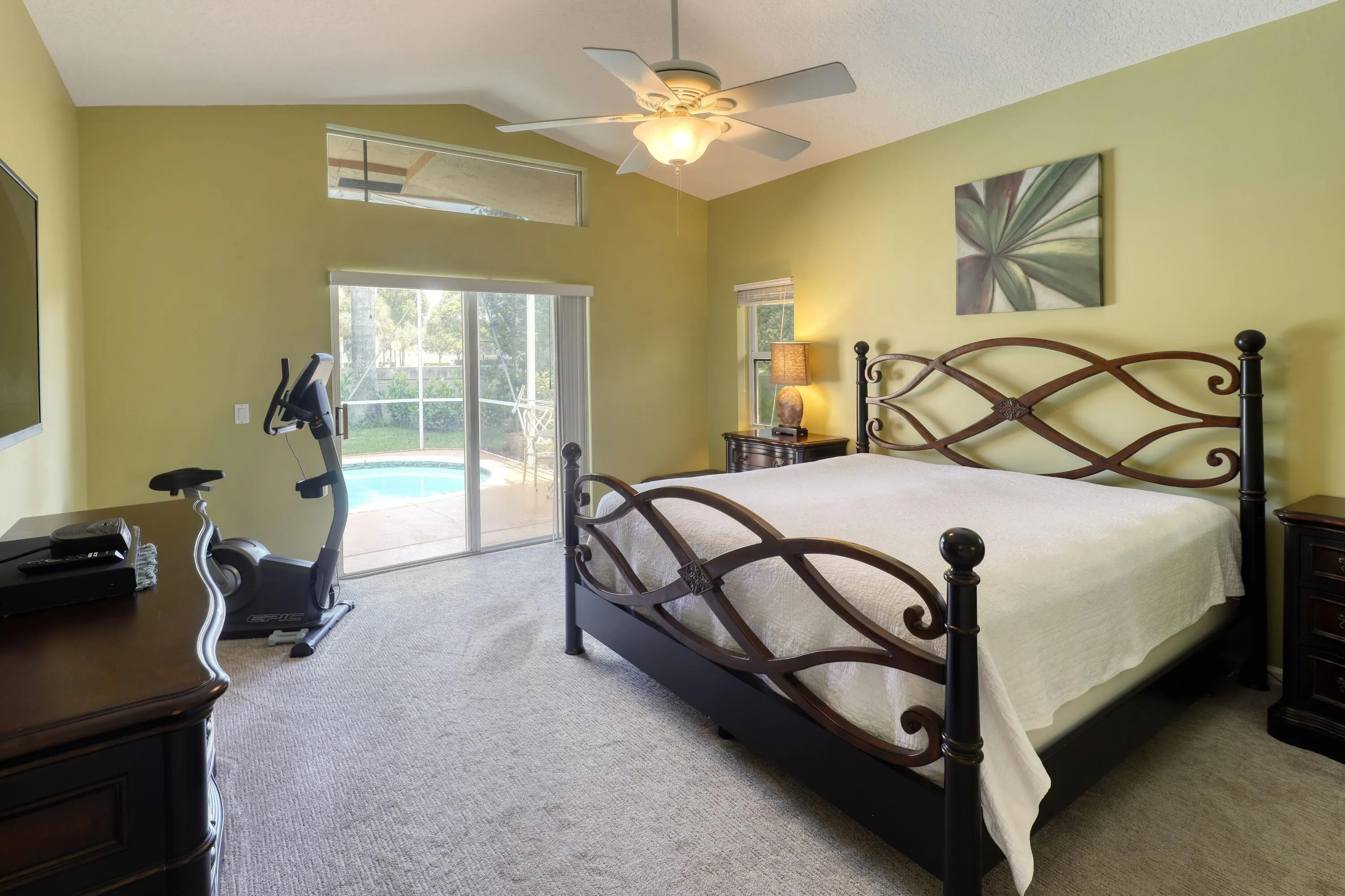 Large primary suite with direct access to the pool, generous natural light, and plenty of space for a king-size bedroom set.