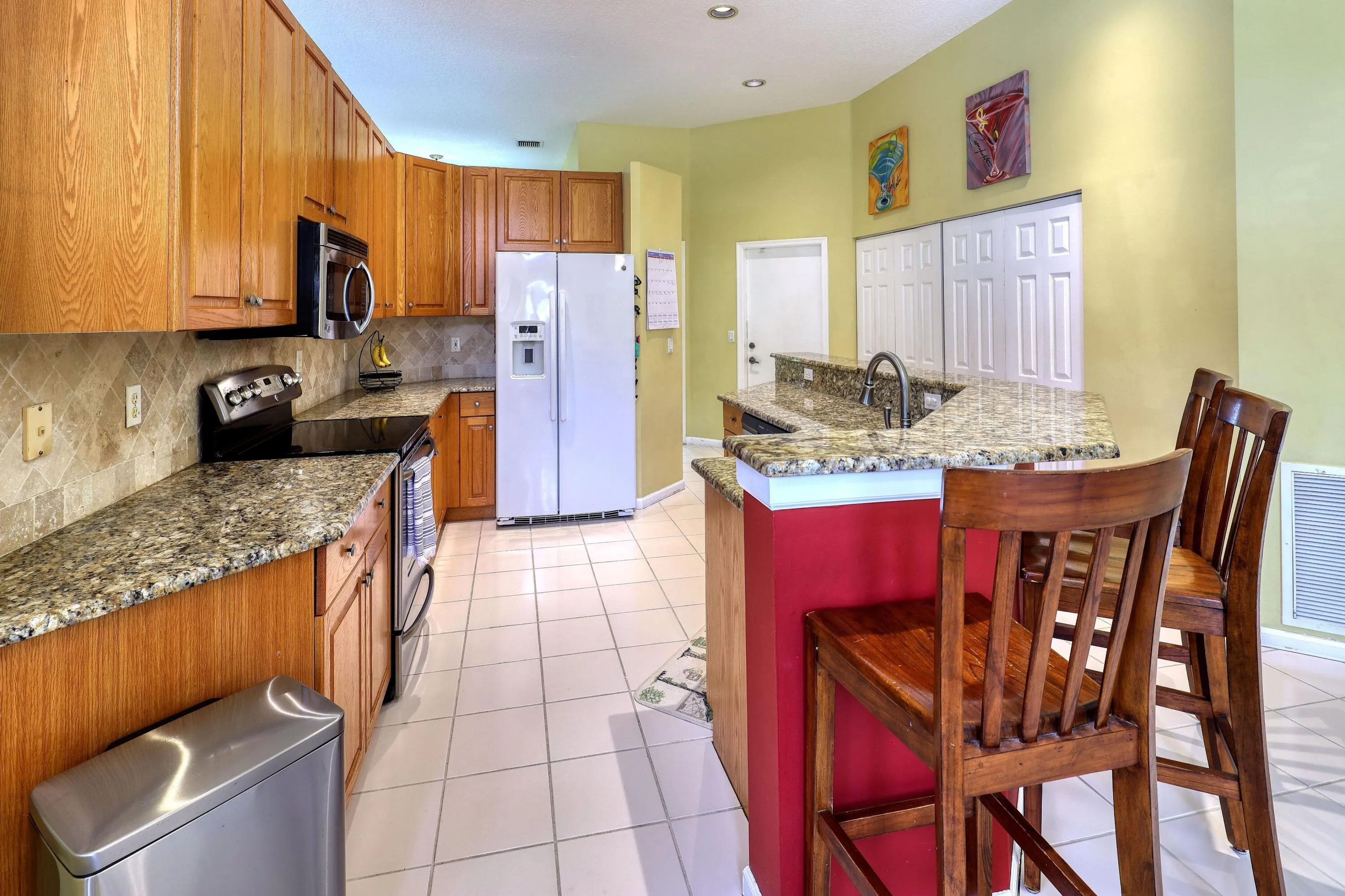 Open kitchen with breakfast bar seating, abundant cabinet space, granite countertops, and a layout designed for everyday living.