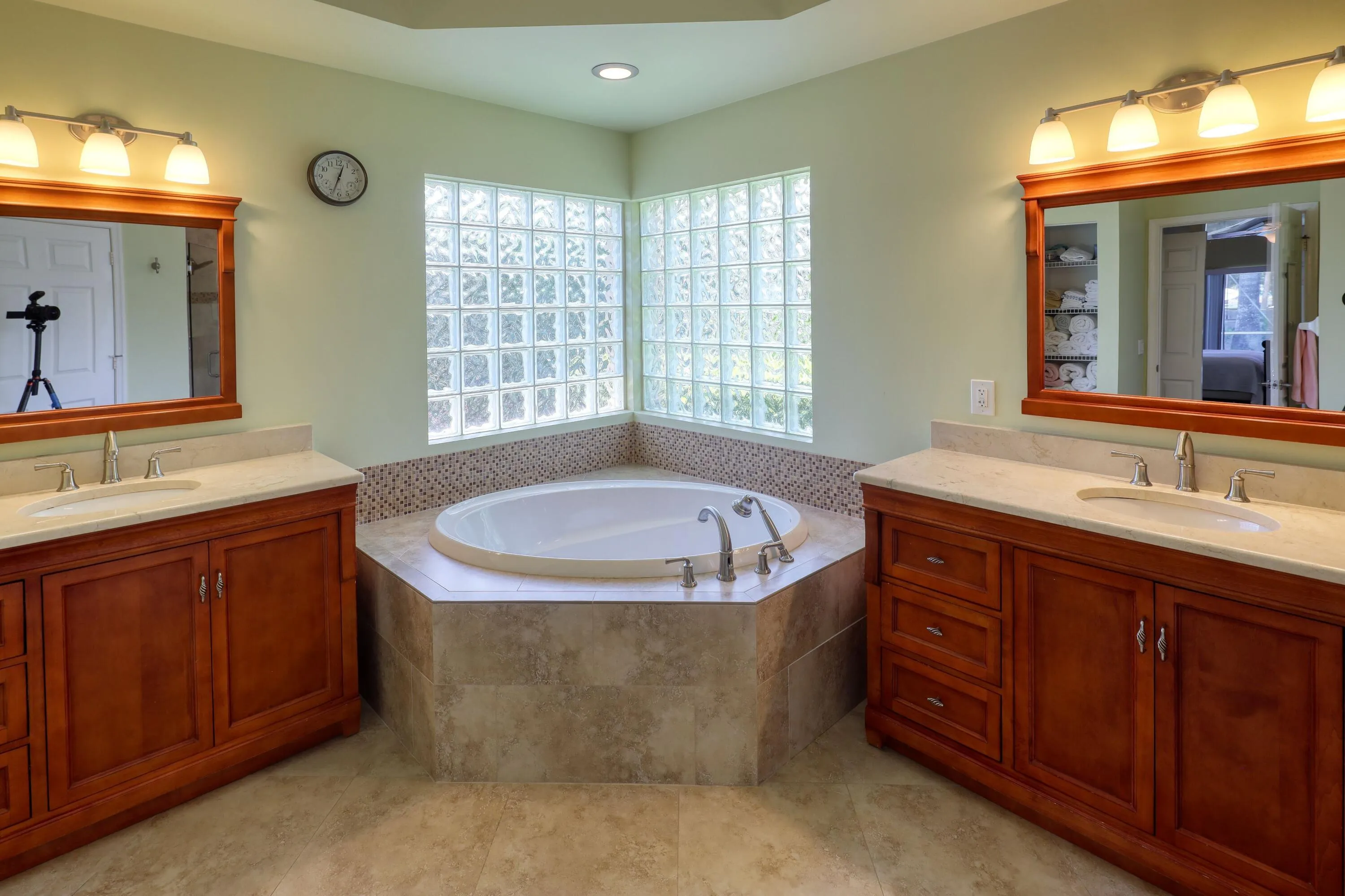 Spa-inspired primary bath with Roman soaking tub, dual vanities, and elegant finishes throughout.