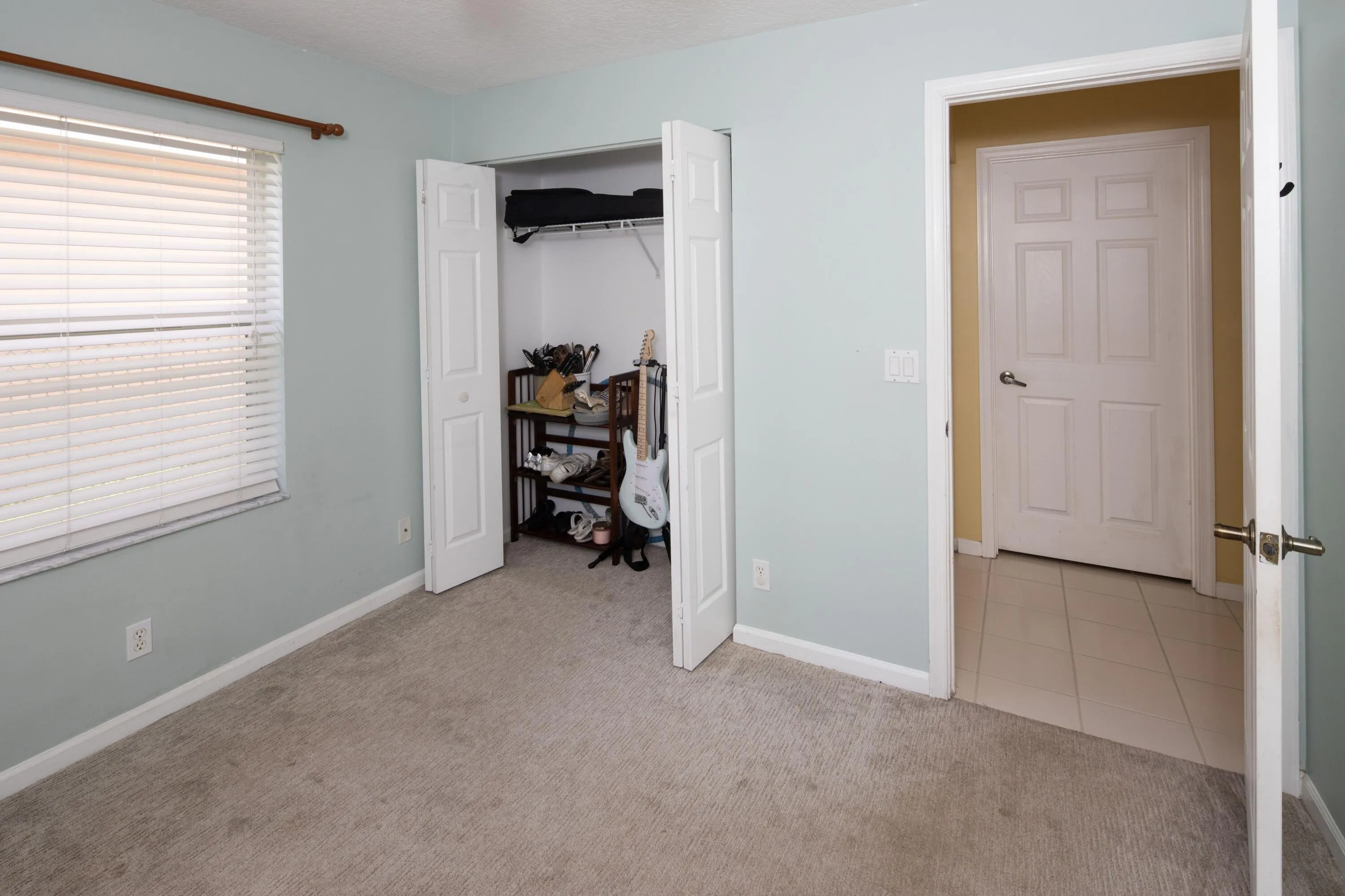 Bright third bedroom with ample closet space and flexible use for family, guests, or a home office.