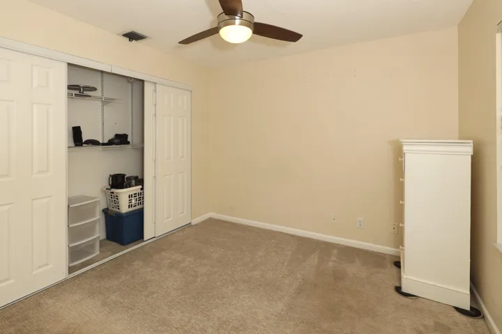 Spacious secondary bedroom with large closet and plenty of natural light, ideal for family or guests.