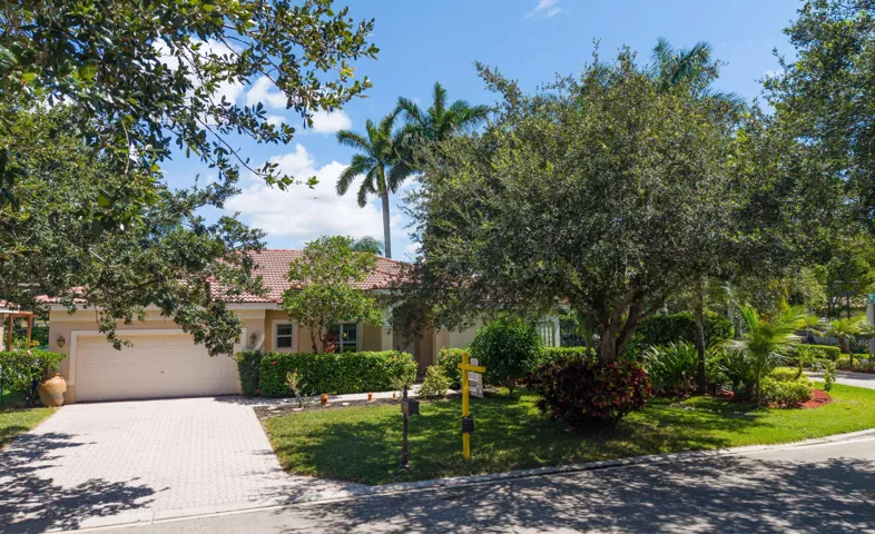 Expansive front yard with mature shade trees, lush landscaping, and inviting curb appeal.