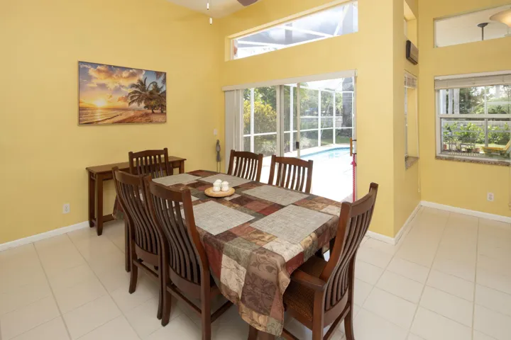 Bright dining area overlooking the pool with large windows and an open floor plan ideal for entertaining.