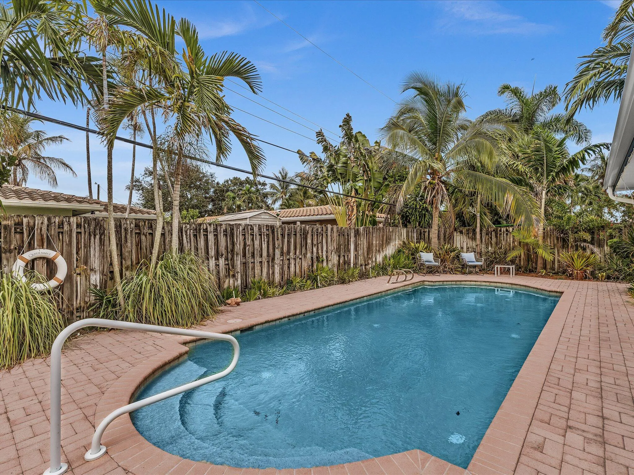 Swimming pool with integrated steps, surrounded by brick paver decking