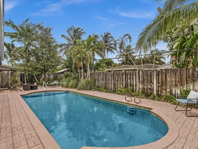 Rectangular swimming pool with integrated steps, surrounded by a brick paver deck