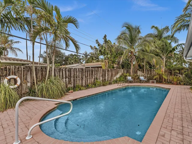 Swimming pool with integrated steps, surrounded by brick paver decking