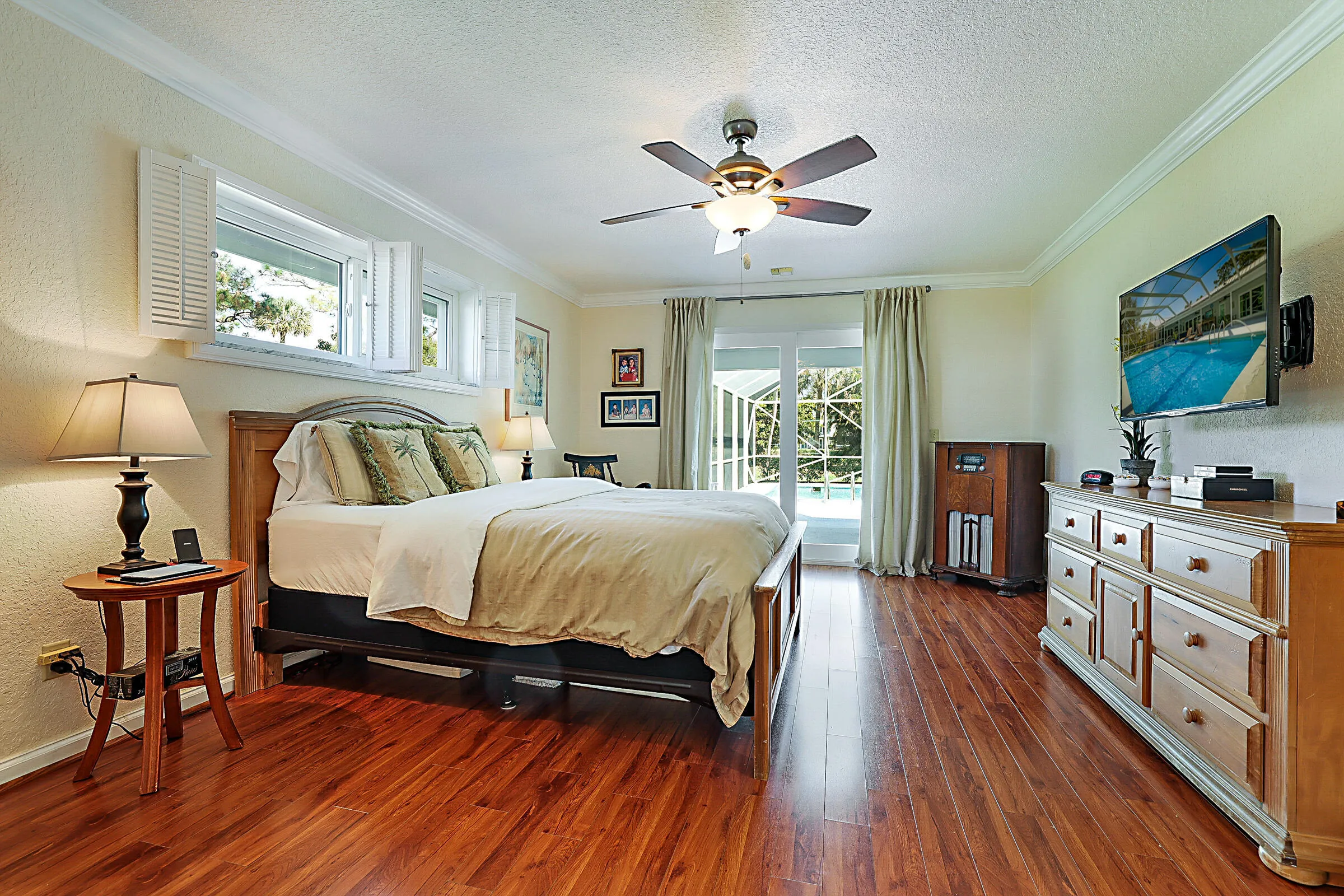 Very large Master bedroom with open view of pool and private seating area on the patio