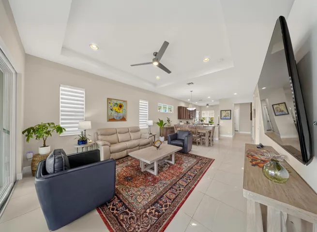Open concept living area featuring recessed lighting, a ceiling fan, and tray ceiling detail