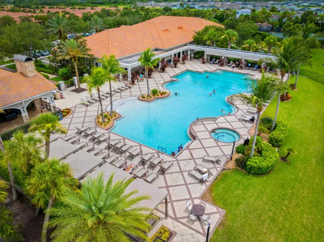Expansive resort-style swimming pool featuring a large main pool, integrated spa, and surrounding paver deck
