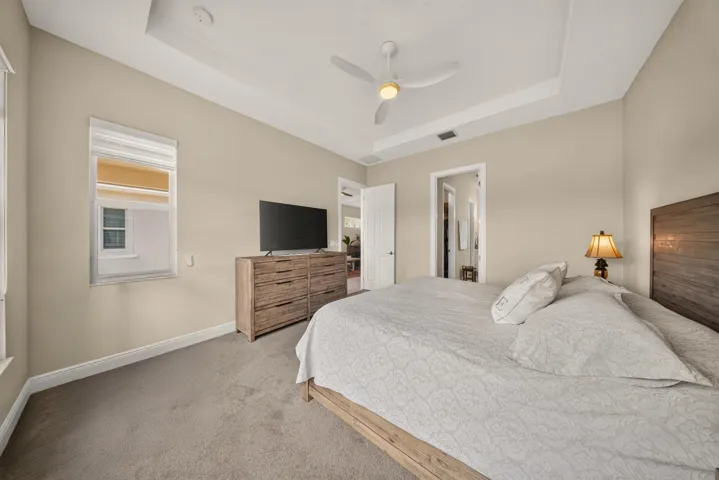 Carpeted bedroom featuring a tray ceiling, recessed lighting, and a ceiling fan